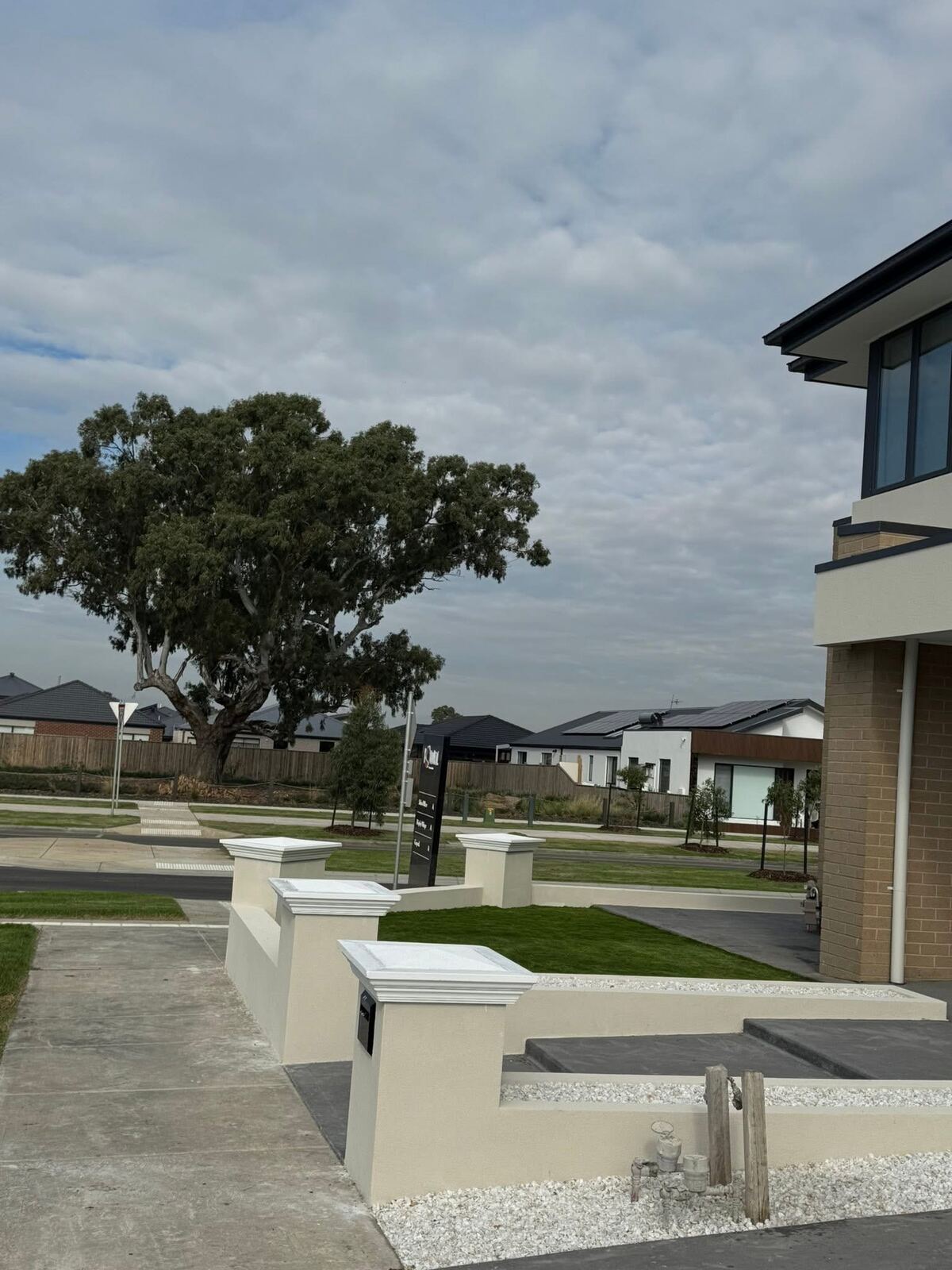 Front lawn, concrete steps and letterbox pillar at a new home