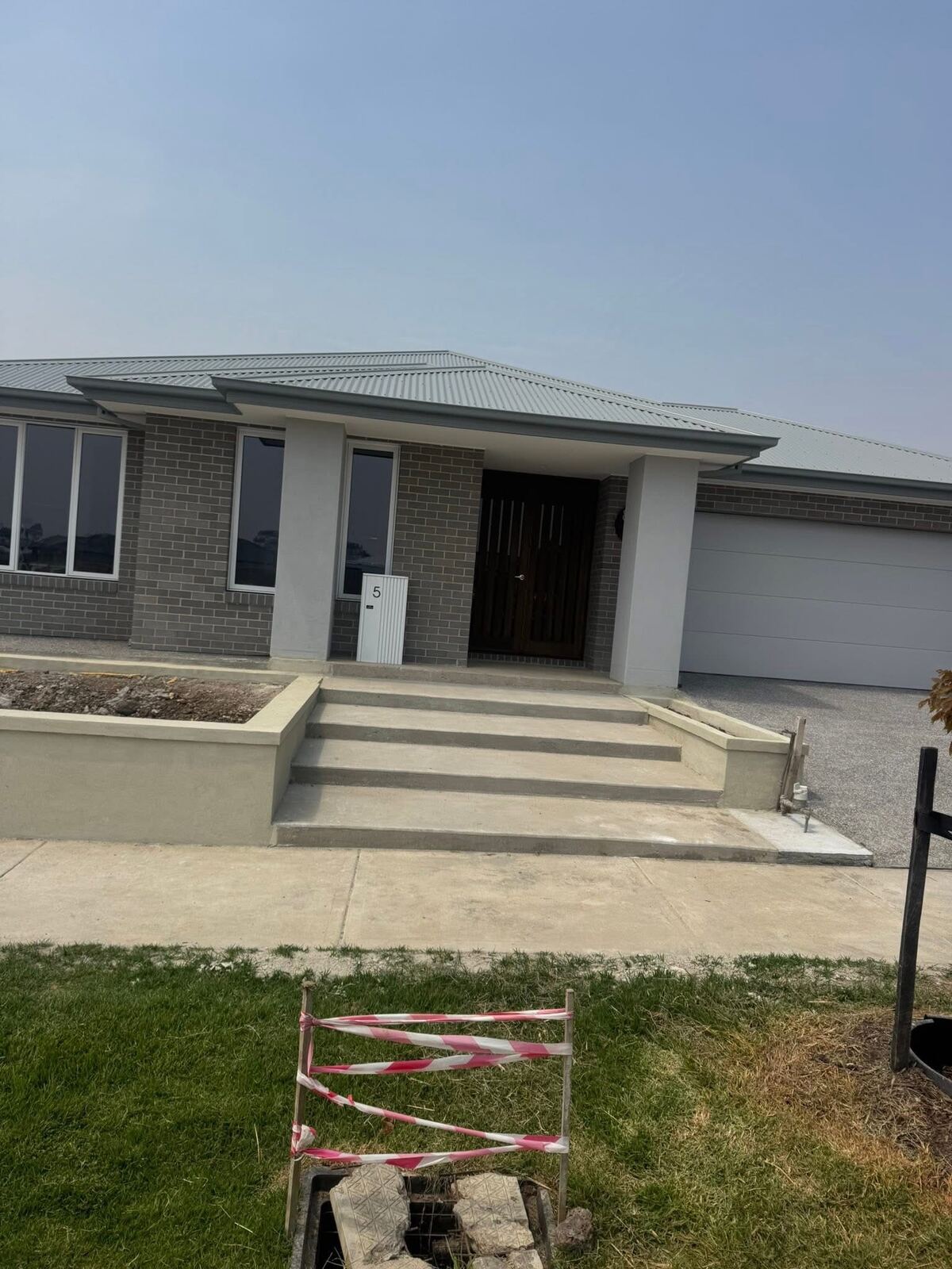 New concrete entry steps up to a front porch